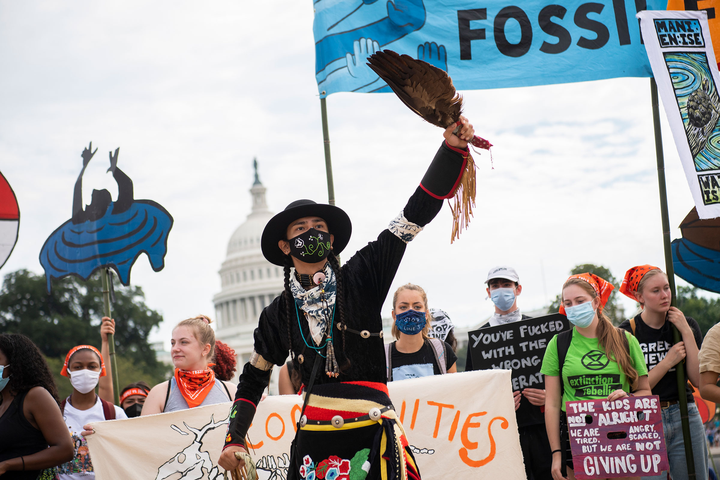A Native American protester in a mask demonstrates with others in front of the U.S. Capitol