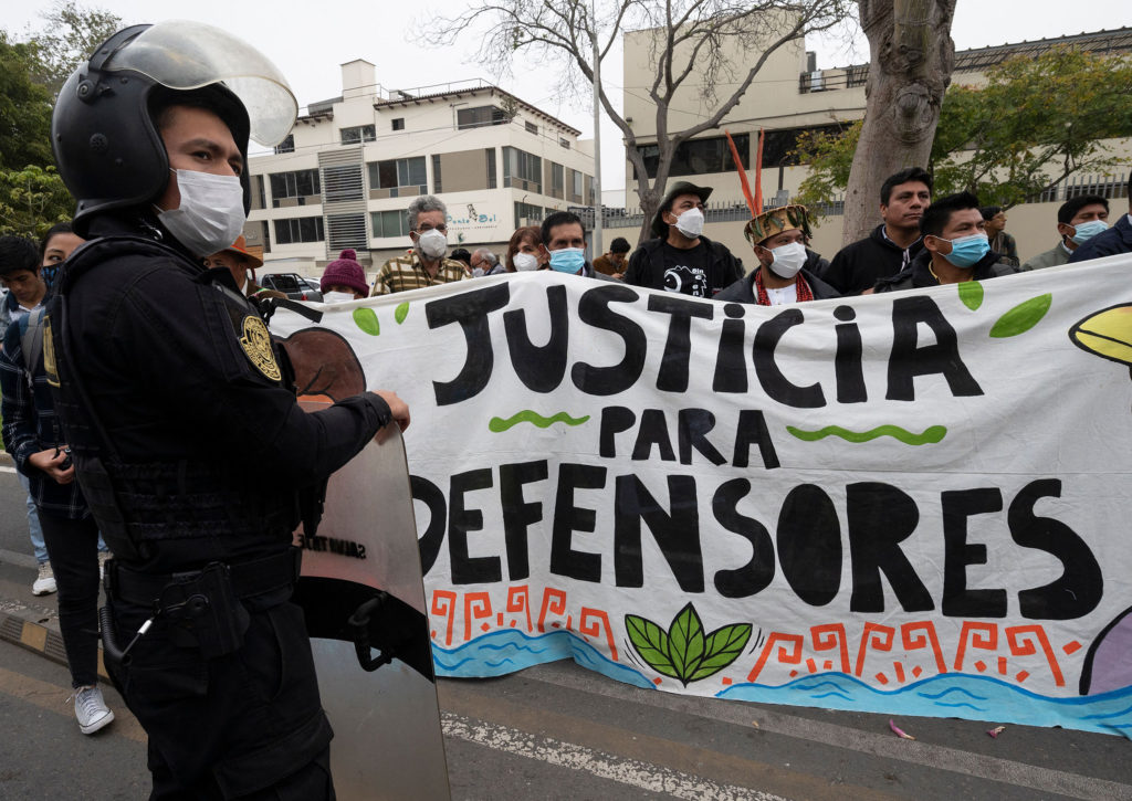 People stand behind a banner reading