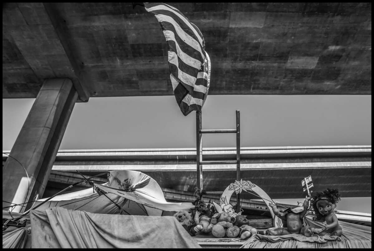 Des poupées et un drapeau sont des commentaires ironiques laissés sur un véhicule sous l'autoroute, sur le point d'être remorqué.