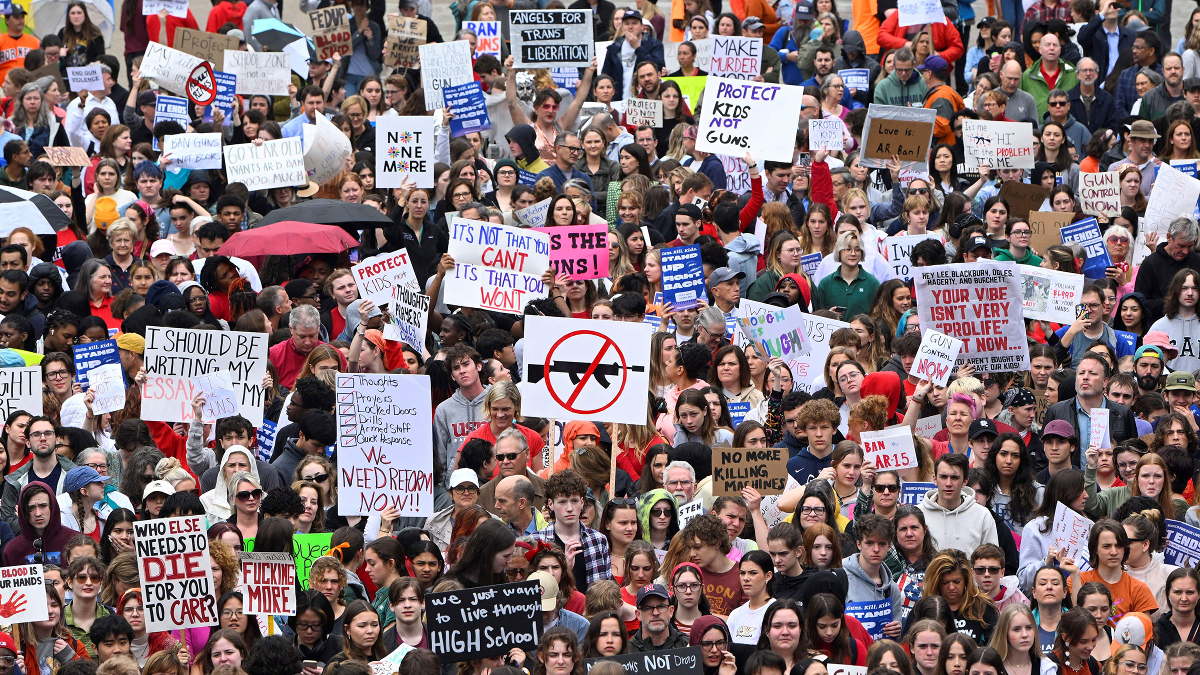 A huge crowd of people displays signs in support of high school students seeking to ban guns from school grounds