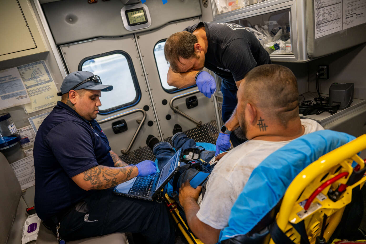 Emergency Medical Technicians William Dorsey and Omar Amezcua assist a person after he called in for chest pain during a heatwave on June 29, 2023 in Eagle Pass, Texas.
