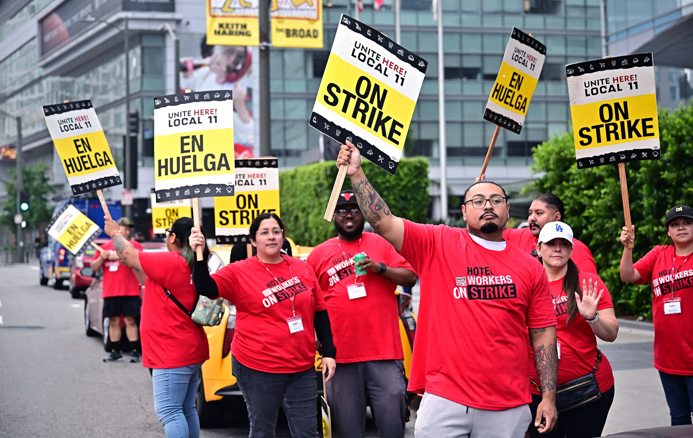 People in red shirts display signs reading