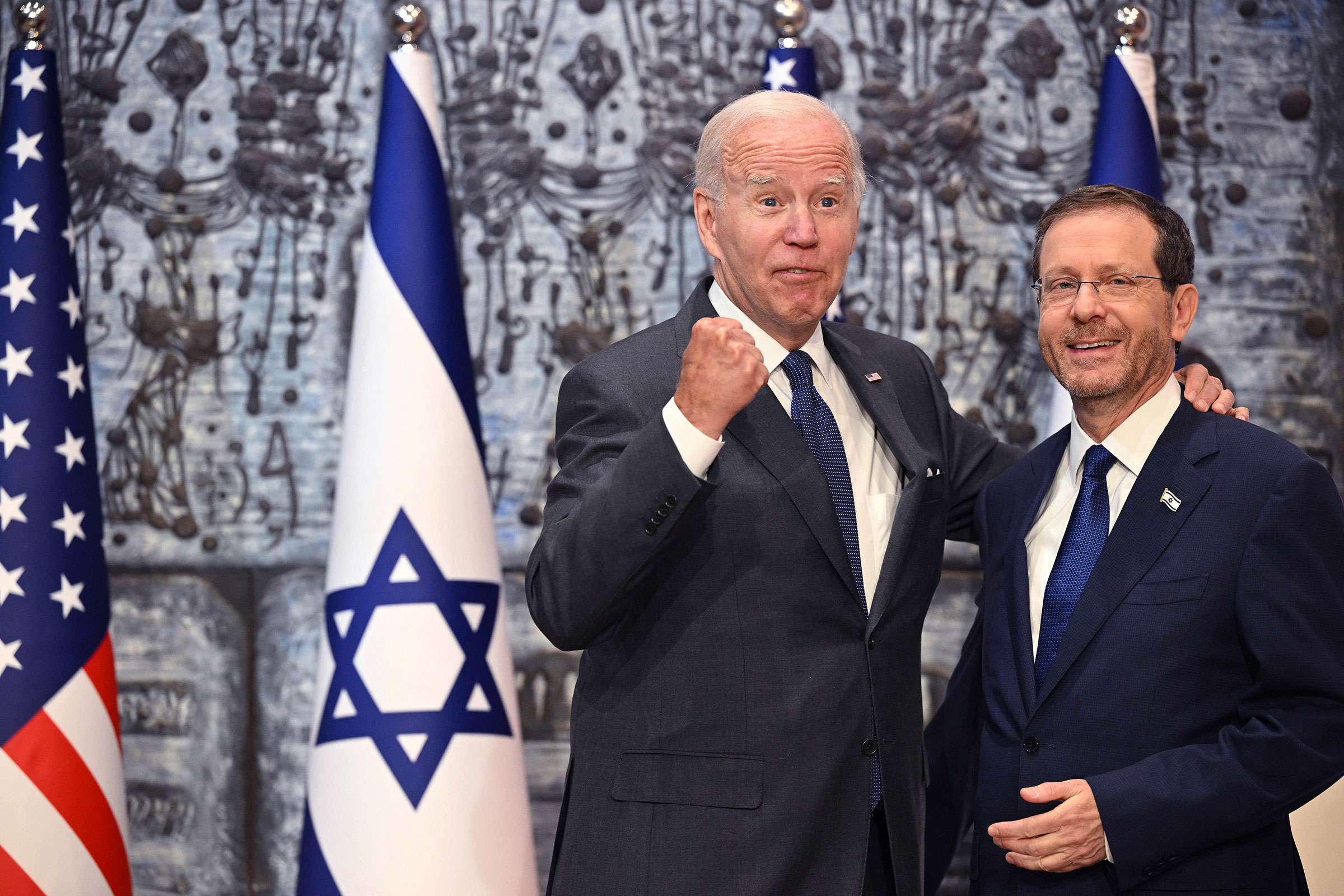Joe Biden pumps his fist while embracing Israeli president Isaac Herzog