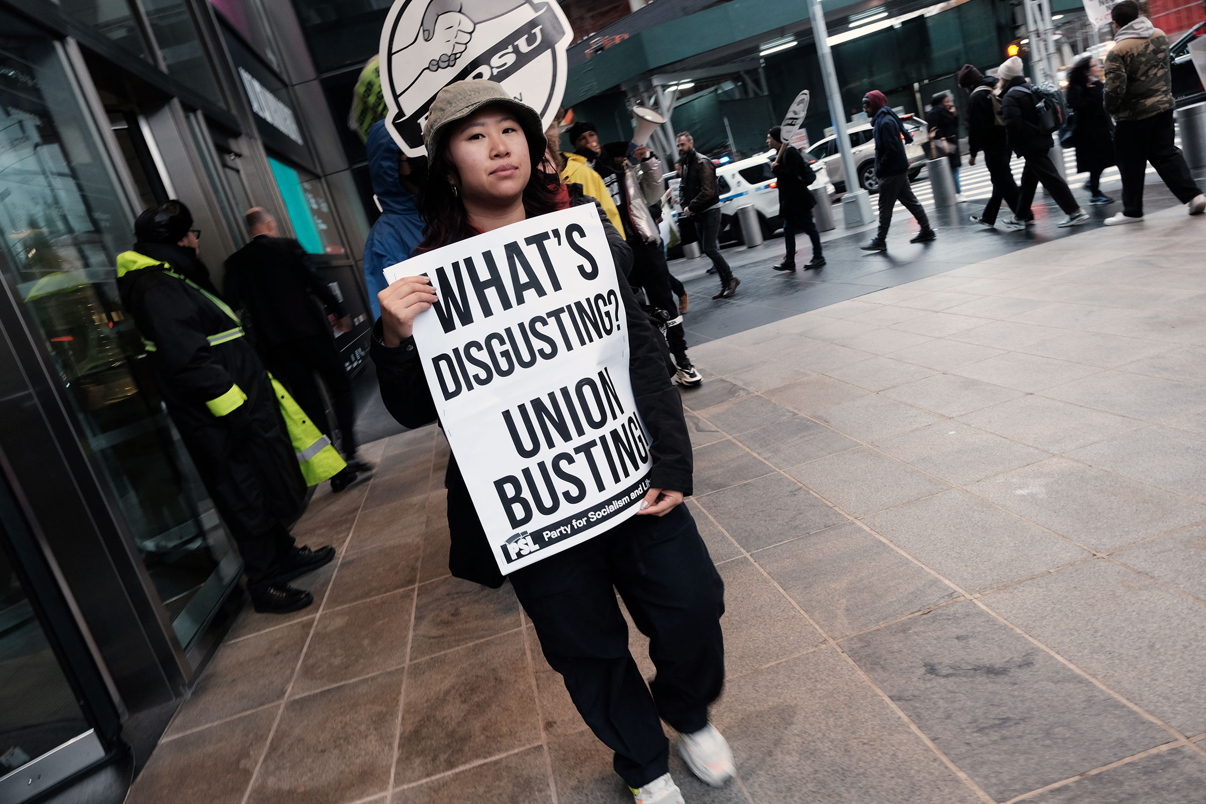 A protester holds a sign reading "WHAT