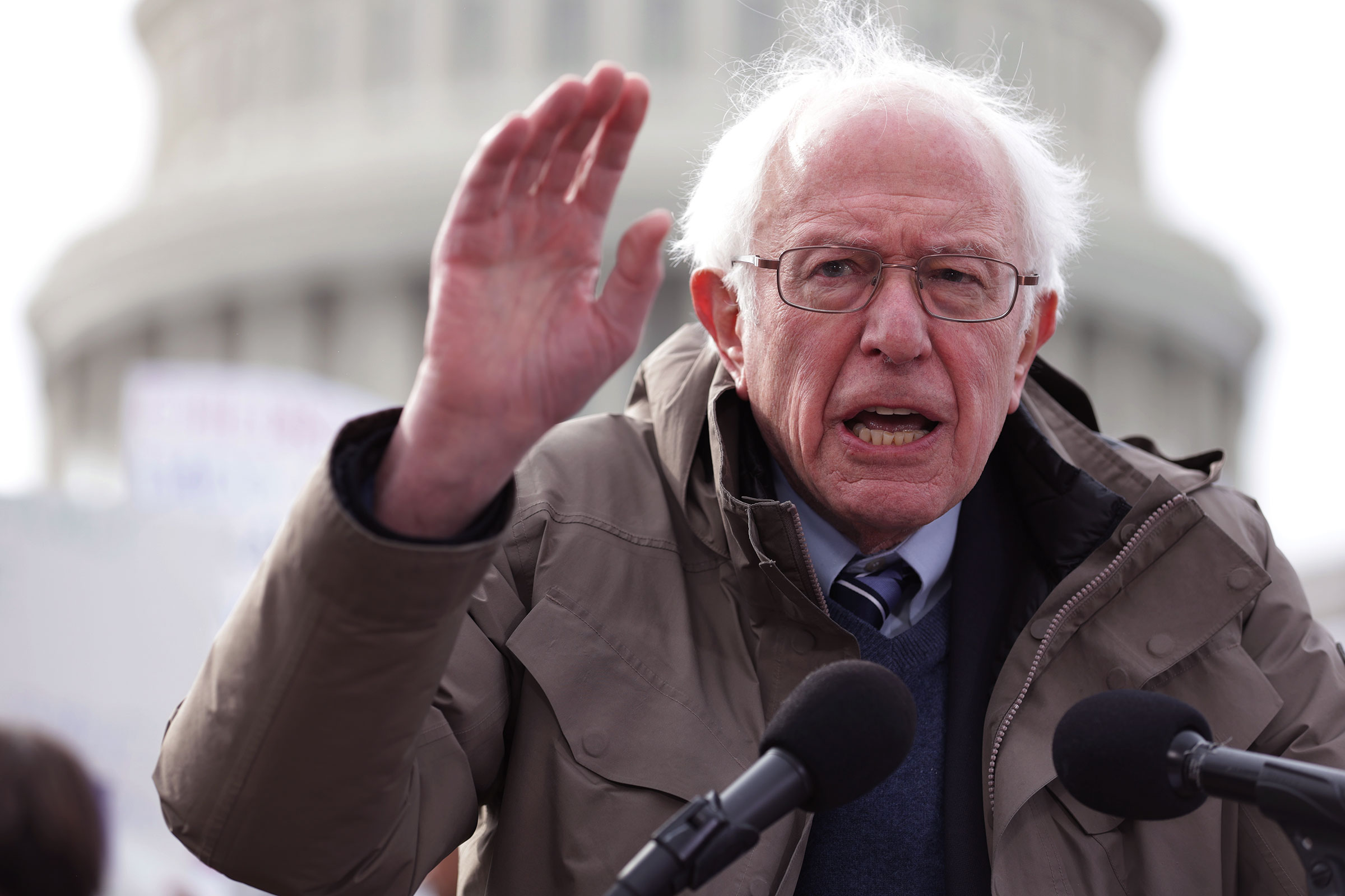 Bernie Sanders gestures while speaking at a podium on the steps of the United States capitol