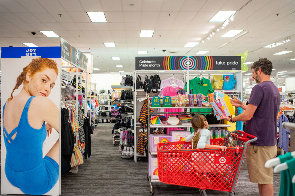 A dad pushes his child in a shopping cart through the Pride section of a Target