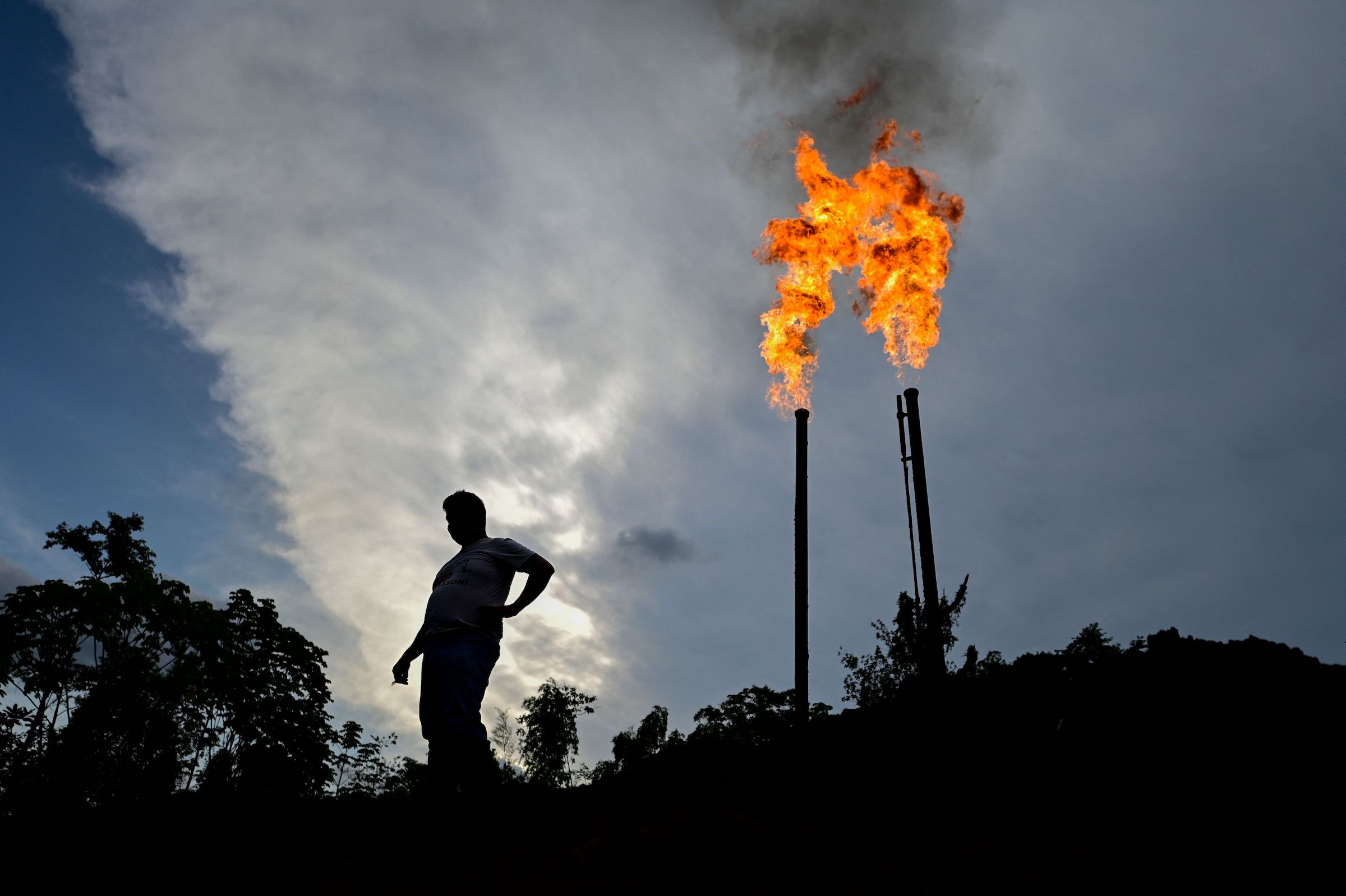 Ecuadorean activist Donald Moncayo Jimenez (49) chief coordinator of the Union of People Affected by Texaco (UDAPT) stands next to a gas flare from the refinery operated by Petroecuador in Shushufindi, in the Sucumbíos Province, Ecuador, on January 14, 2023.