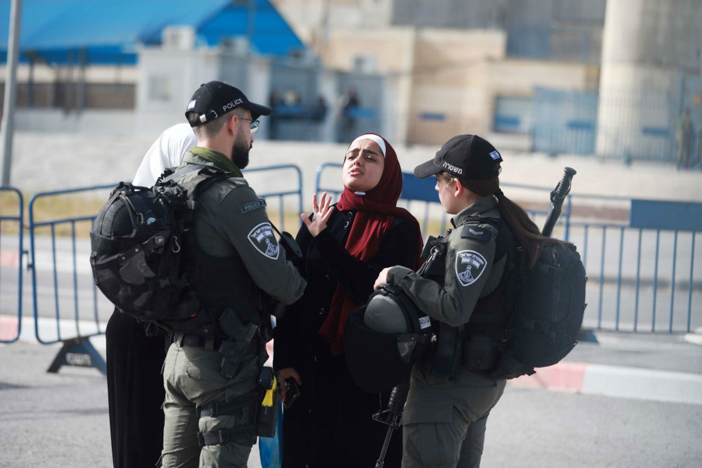 Two IDF officers harrass a young woman in a hijab