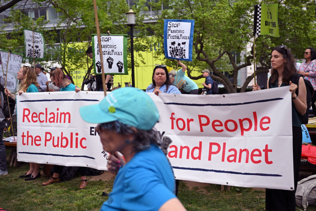 People stand behind a banner reading