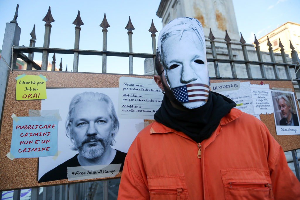 A protester in a mask made to resemble Julian Assange