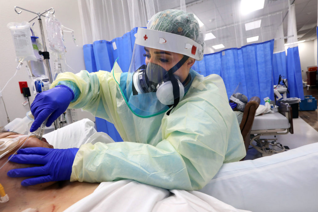A nurse intubates a patient