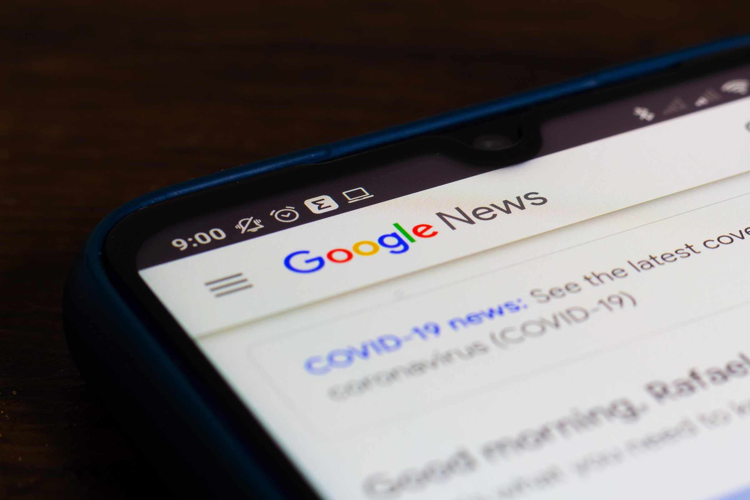 a phone is seen displaying the Google search results for covid-19