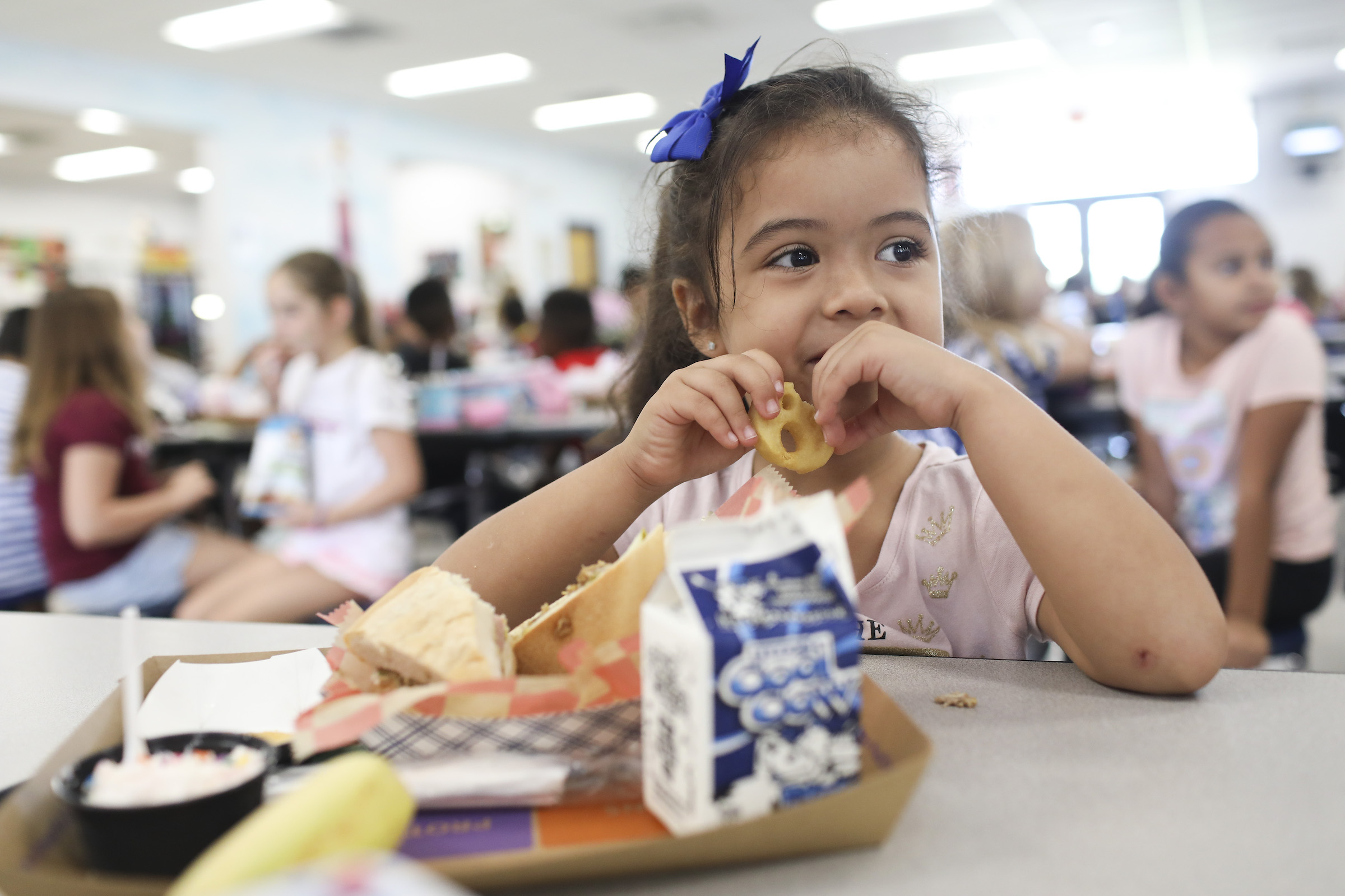 Valerie Yanez, 4 eats a smiley face fry during her lunch period in the cafeteria at Doby Elementary School in Apollo Beach, Florida on October 4, 2019.