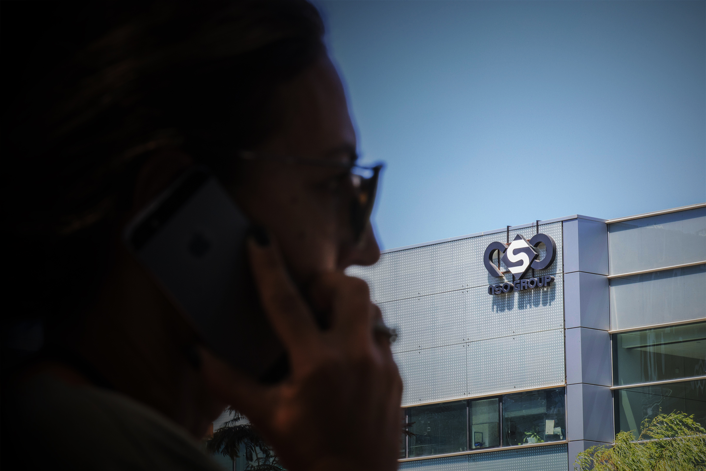 A woman talks on her cell phone in front of the headquarters of an international surveillance service