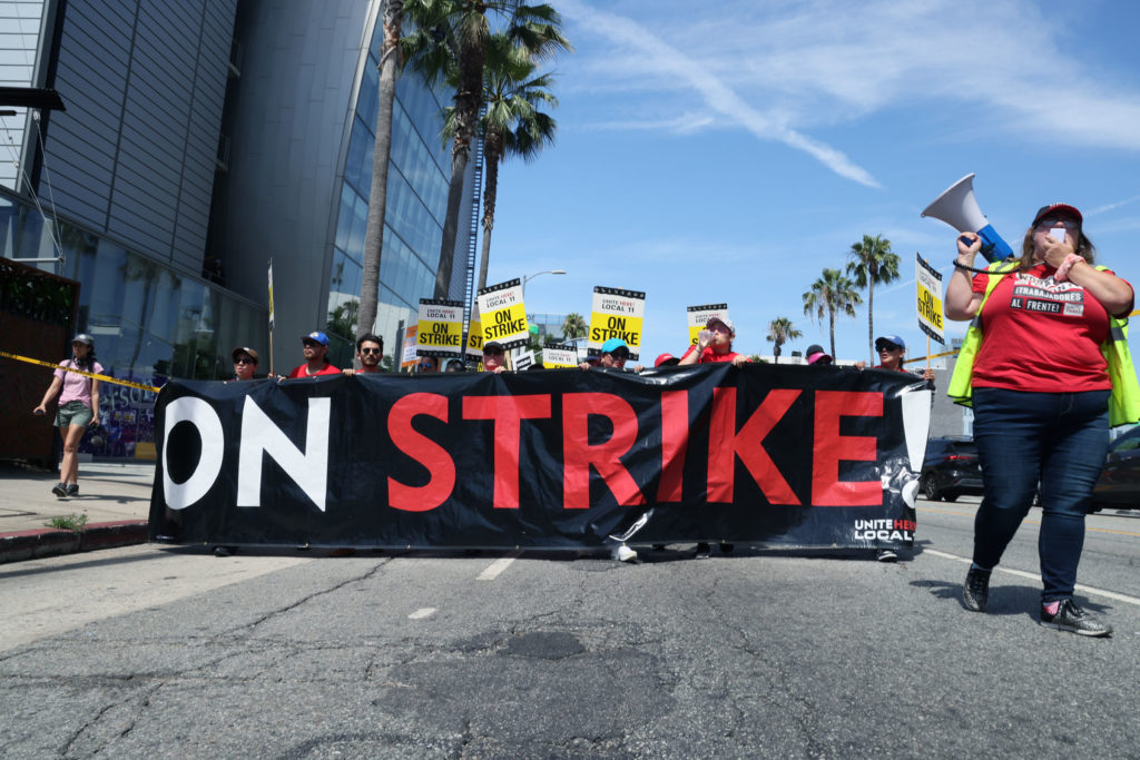 People march behind a banner reading