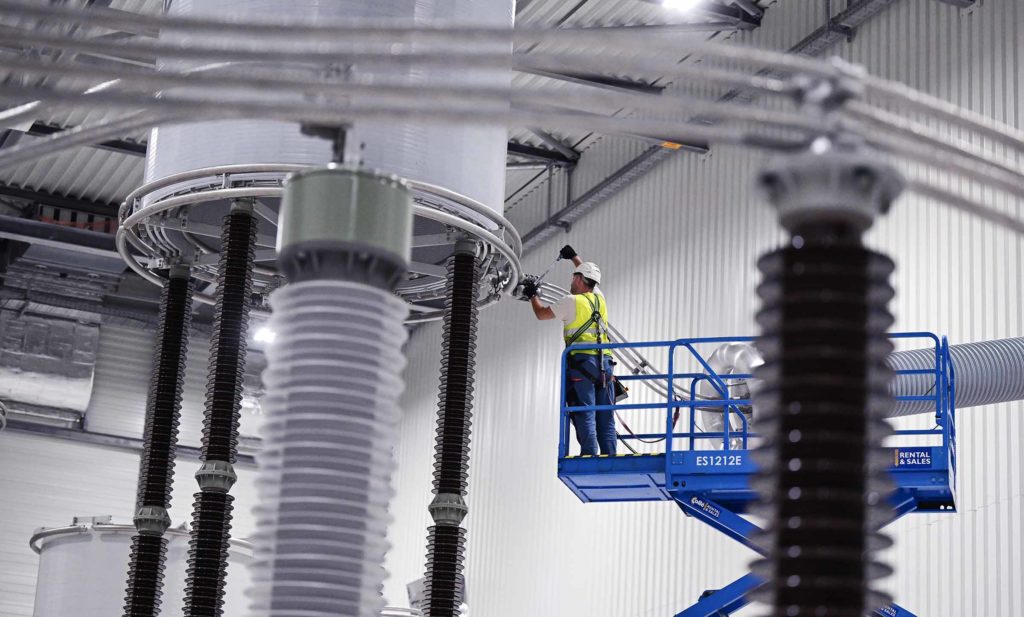 A worker adjusts a piece of machinery in a nuclear power plant