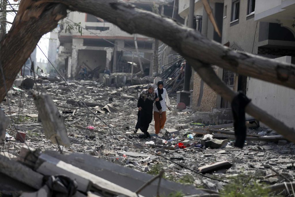 People walk through the rubble that was once their homes