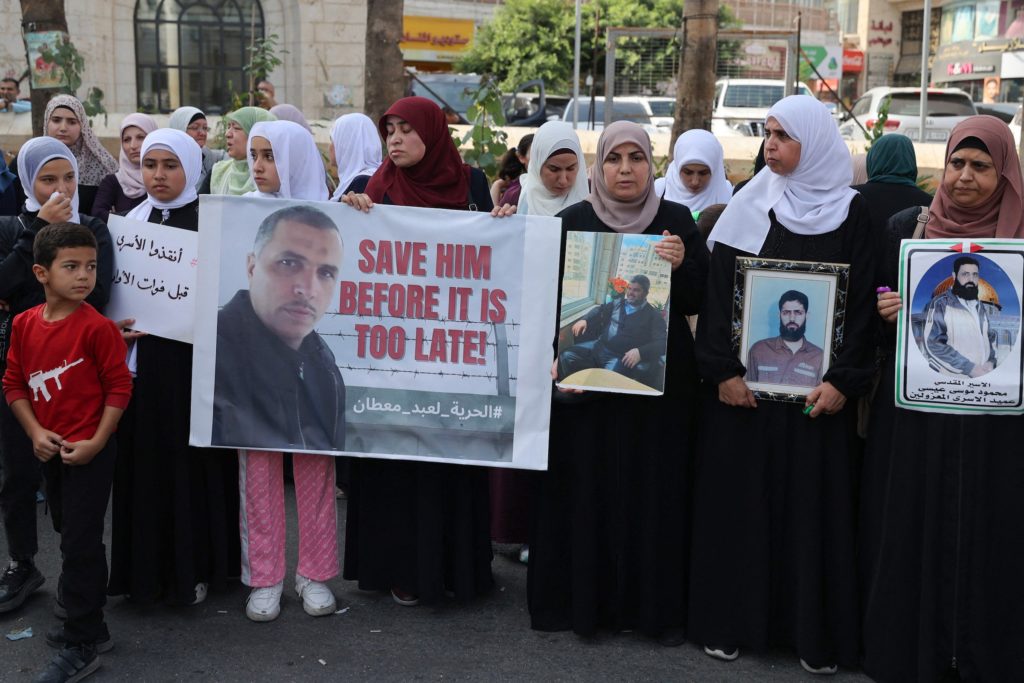 Relatives of Palestinians detained in Israeli jails carry pictures of prisoners as they demonstrate to demand their release and in solidarity with the people of the Gaza Strip, in the occupied West Bank city of Ramallah on October 28, 2023.