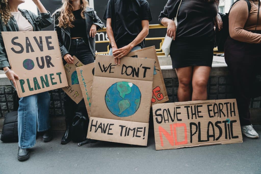 People are holding banner signs while they are going to a demonstration against climate change.