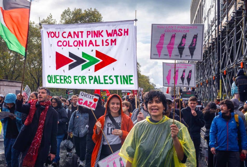 Protesters march under a banner reading "YOU CAN