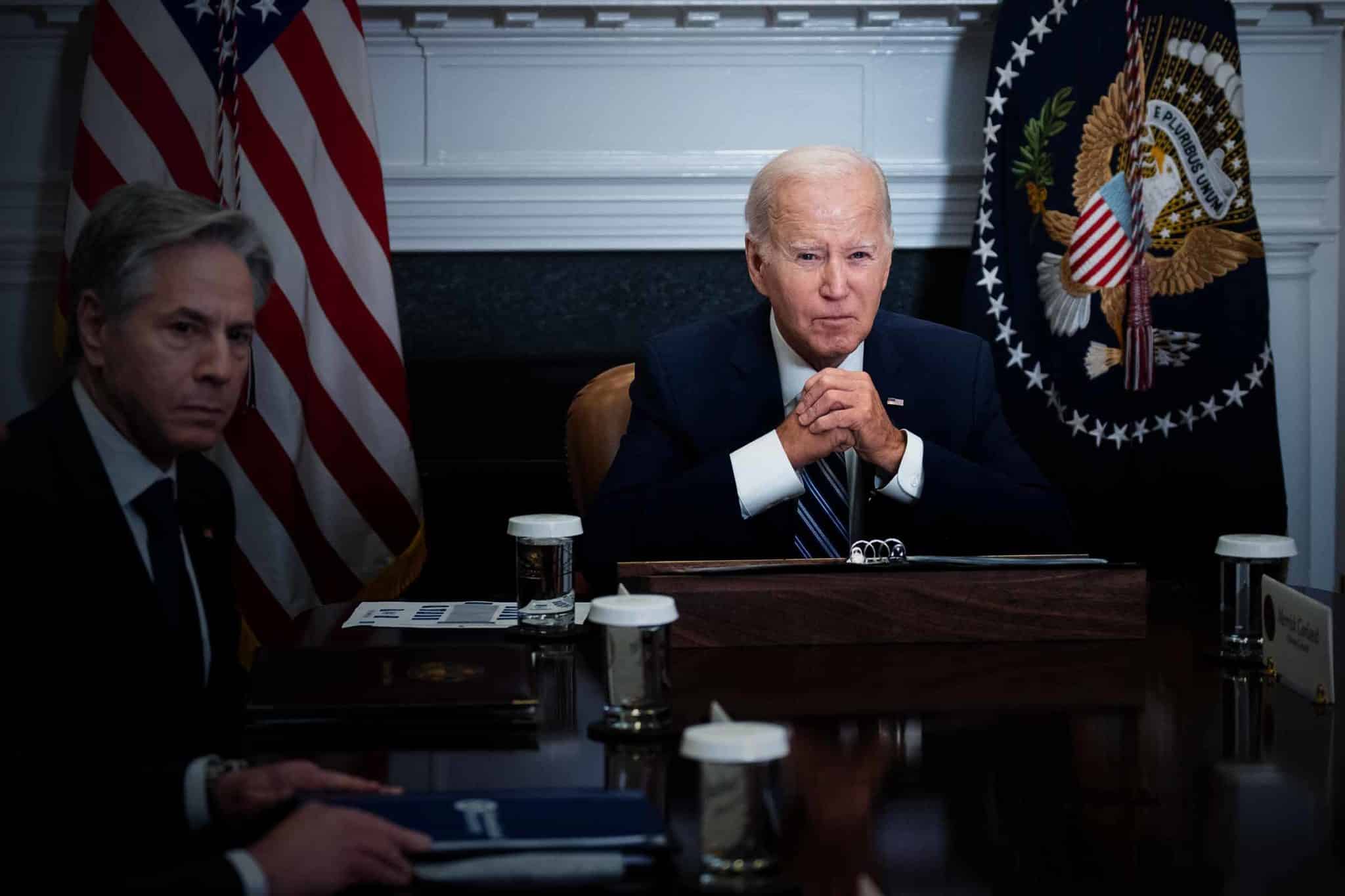 Joe Biden sits next to Anthony Blinken