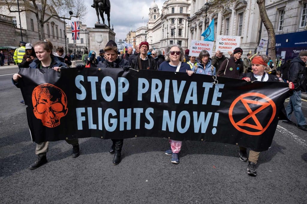 People march behind a banner reading