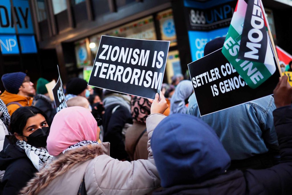 A person holds a sign reading