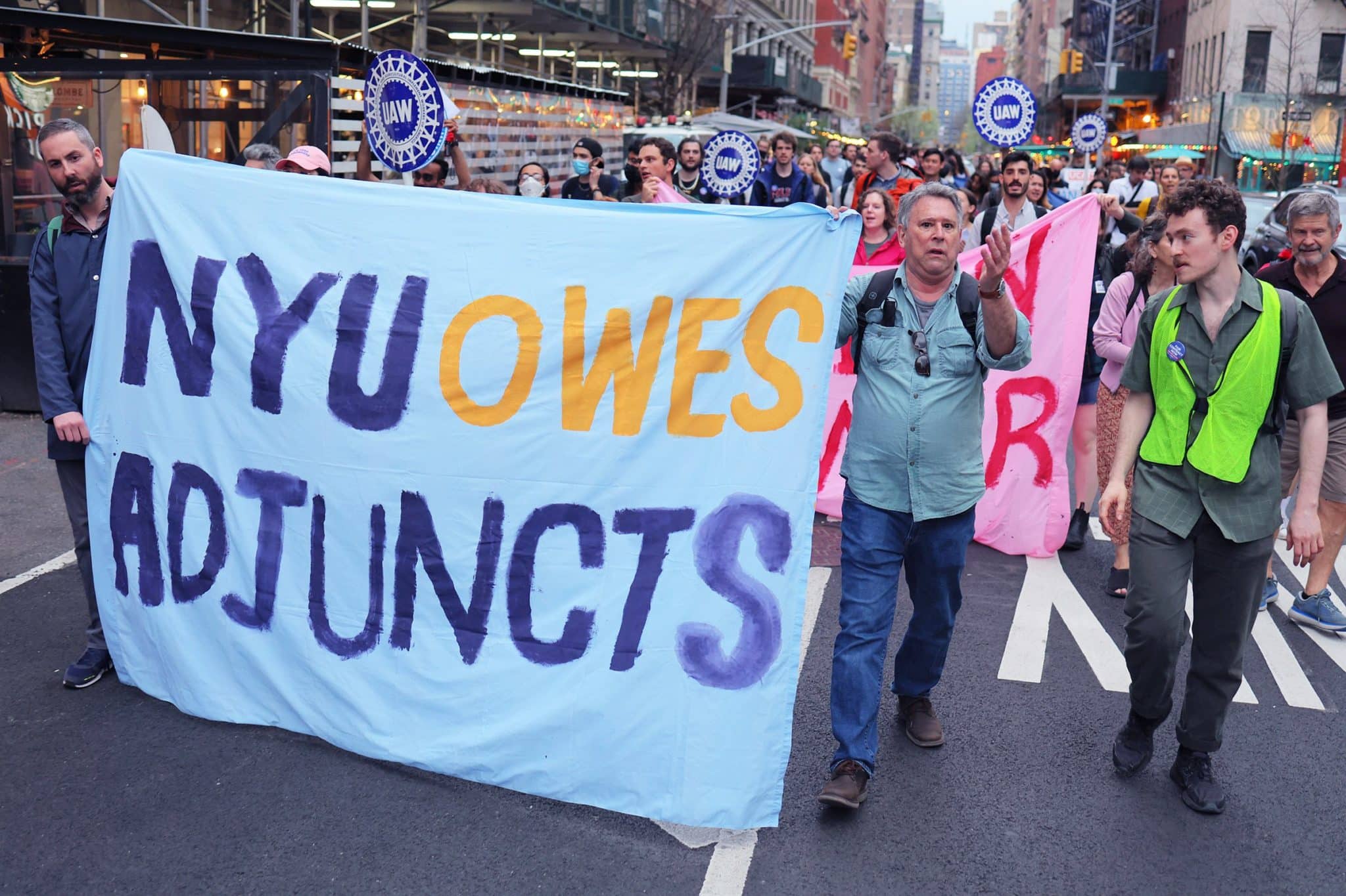 People march behind a banner reading