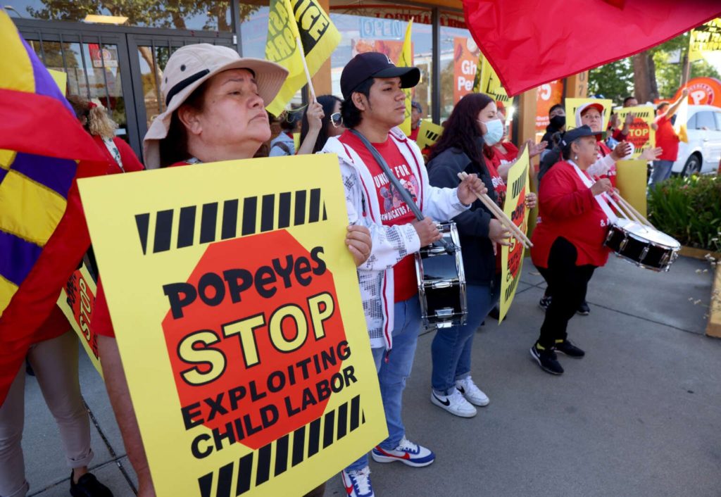 Fast food worker holds up sign saying