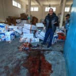 A man gestures near a pool of blood at an UNRWA warehouse and distribution centre in Rafah, in the southern Gaza Strip, following an Israeli strike on March 13, 2024.